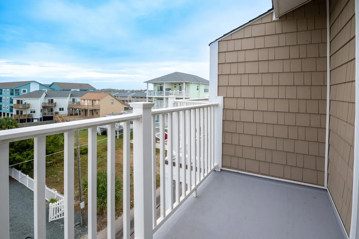 This photo features the view from a private balcony overlooking the neighborhood, with a sturdy railing and clear sightlines. The space is perfect for morning coffee or simply soaking in the ambiance, reinforcing the connection between the condo and the outdoors.